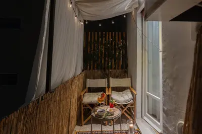 a balcony with two chairs and a table and a window at Casa Margherita in Rome