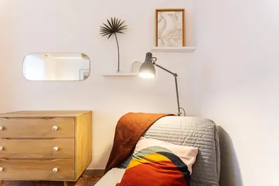 a bedroom with a bed and a lamp and a dresser at Casa Margherita in Rome