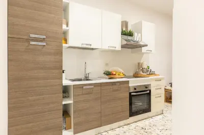a kitchen with white cabinets and a sink at Casa Margherita in Rome