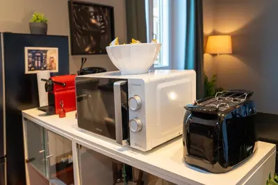 a counter with a microwave and a bowl on it at CupolHome - Meraviglia A San Pietro in Rome