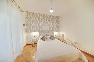 a bedroom with a white bed and a wall at Domus Mariposa in Rome