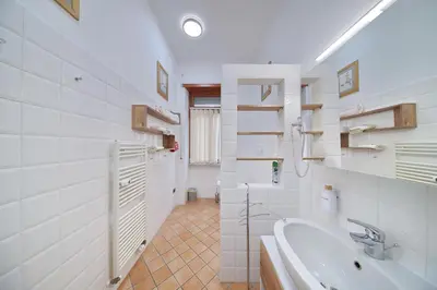 a white bathroom with a tub and a sink at Domus Mariposa in Rome
