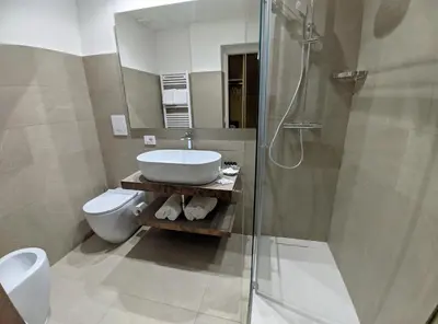 a bathroom with a sink and a toilet and a shower at Astom Suites in Rome