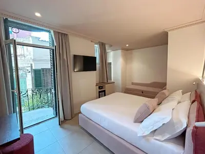 a hotel room with a bed and a balcony at Astom Suites in Rome