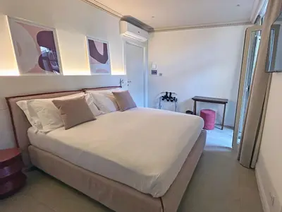 a bedroom with a large bed with white sheets and pillows at Astom Suites in Rome