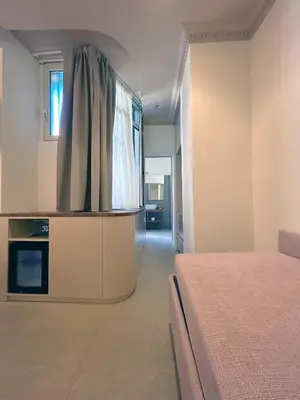 a bedroom with a bed and a kitchen in it at Astom Suites in Rome