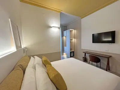 a hotel room with a bed and a desk at Astom Suites in Rome