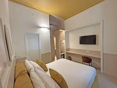 a hotel room with a bed and a tv on the wall at Astom Suites in Rome