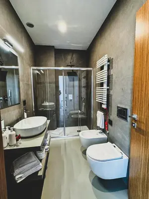 a bathroom with two sinks and a toilet and a shower at J Maluni City Hotel in Rome