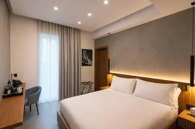 a hotel room with a bed and a desk at J Maluni City Hotel in Rome