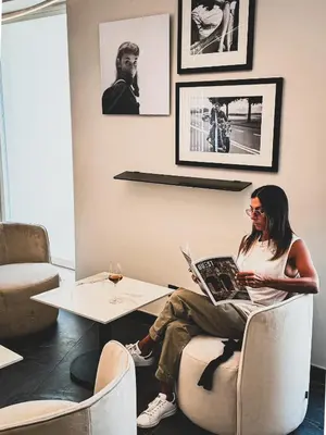a woman sitting in a chair with a laptop at J Maluni City Hotel in Rome
