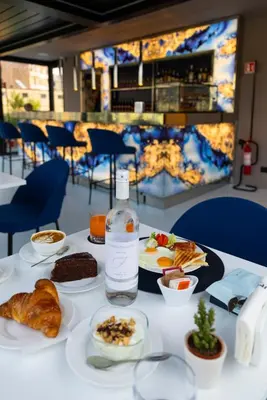 a table with plates of food and a bottle of water at J Maluni City Hotel in Rome
