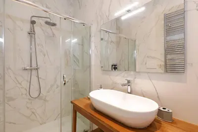a white bathroom with a sink and a shower at Zelo Apartment by Nosdom Properties in Rome
