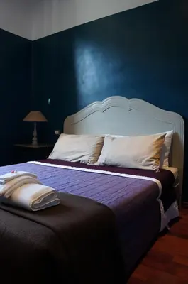 a bedroom with a large bed with a blue wall at A Casa Di Elle in Rome