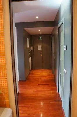a hallway leading to a room with wood floors at A Casa Di Elle in Rome