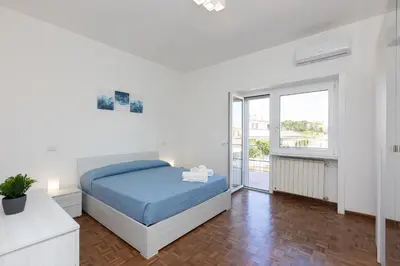 a white bedroom with a bed and a window at Baldo by Rental in Rome in Rome