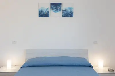 a bedroom with a blue bed and two lamps at Baldo by Rental in Rome in Rome