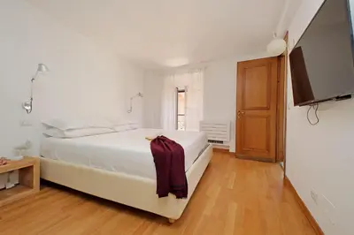 a bedroom with a bed and a flat screen tv at Via dell'Orso Charme - My Extra Home in Rome