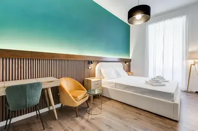 a bedroom with a bed and a desk and a chair at BMGA l Ottaviano Lux 3Bdr Apartment in Rome