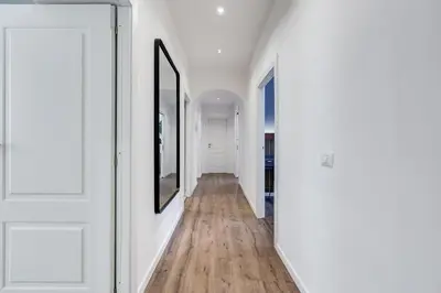 a hallway with white walls and wood floors at BMGA l Ottaviano Lux 3Bdr Apartment in Rome