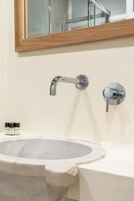 a bathroom sink with two faucets and a mirror at Reginella Luxury Apartment in Rome