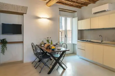 a kitchen with a table and chairs in a room at Reginella Luxury Apartment in Rome