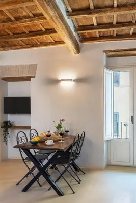 a dining room with a wooden table and chairs at Reginella Luxury Apartment in Rome