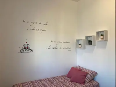 a bedroom with a bed and writing on the wall at Bellissimo Appartamento- metro Battistini - Vaticano - 120mq in Rome
