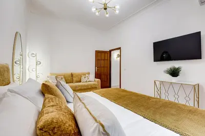 a bedroom with a bed with white sheets and a tv at NEW Vatican BIG apartment - ROMEDREAMHOME in Rome