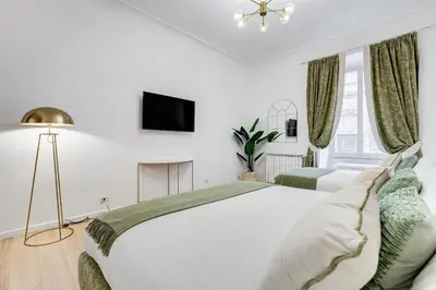 a white bedroom with a large bed and a tv at NEW Vatican BIG apartment - ROMEDREAMHOME in Rome