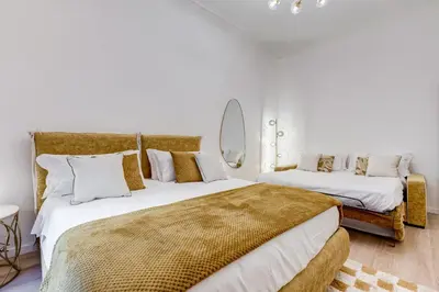 two beds in a bedroom with a mirror on the wall at NEW Vatican BIG apartment - ROMEDREAMHOME in Rome