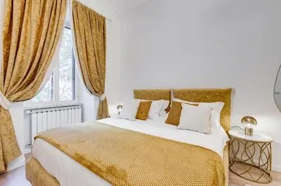 a bedroom with a large bed with yellow and white pillows at NEW Vatican BIG apartment - ROMEDREAMHOME in Rome