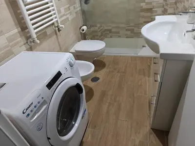 a washing machine in a bathroom with a sink and a toilet at Premium One-Bedroom Apartment plus sofa bed, Near Vatican - newly renovated in Rome