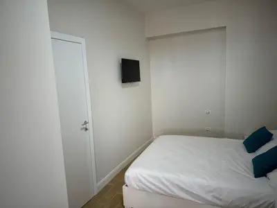 a small bedroom with a bed and a tv on the wall at Premium One-Bedroom Apartment plus sofa bed, Near Vatican - newly renovated in Rome