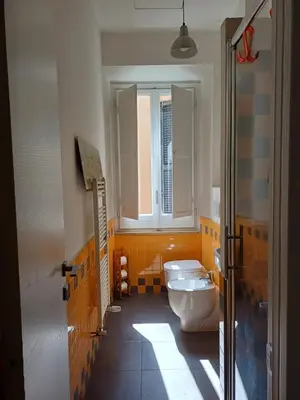 a bathroom with a toilet and a window at Greta's house in Rome