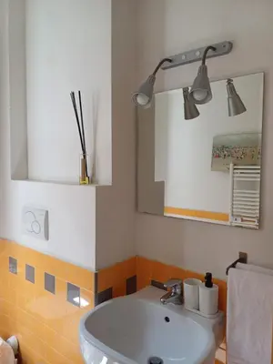 a bathroom with a white sink and a mirror at Greta's house in Rome