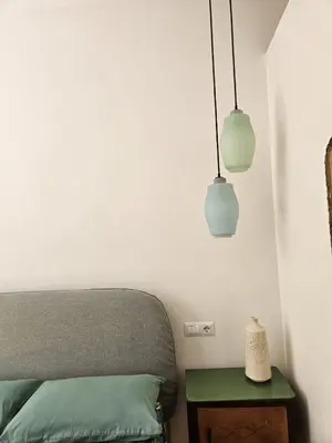 a bedroom with a bed and two pendant lights at Home Rome Borsieri in Rome
