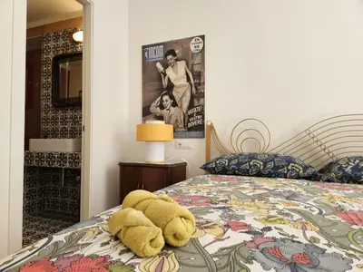 a teddy bear sitting on top of a bed at Home Rome Borsieri in Rome