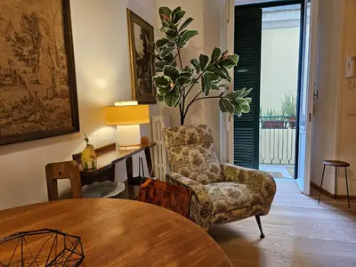 a living room with a table and a chair at Home Rome Borsieri in Rome