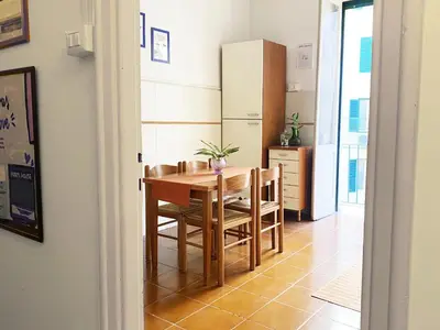 a kitchen with a table and chairs and a refrigerator at Appartamento tipico Romano - Rione XXII Apartment in Rome