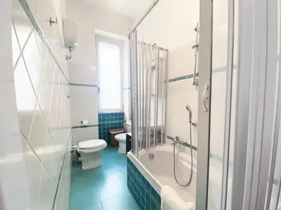 a bathroom with a tub and a toilet and a shower at Appartamento tipico Romano - Rione XXII Apartment in Rome