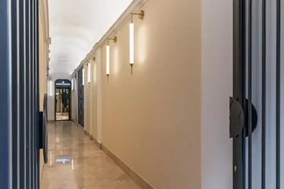 a corridor in a building with white walls and a long hallway at Townhouse Condotti 29 in Rome