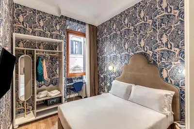 a bedroom with blue and white wallpaper and a bed at Townhouse Condotti 29 in Rome