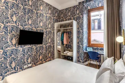 a bedroom with a blue and white wallpaper at Townhouse Condotti 29 in Rome