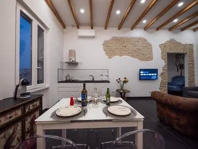 a kitchen and living room with a table and chairs at ConTe Green House - 2 Apartments in Rome