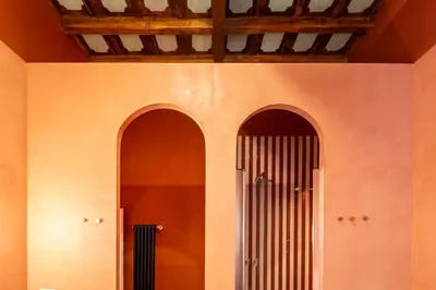 two arched doors in a wall with a radiator at ROMAC Baullari IV Large apartment in Campo de' Fiori in Rome