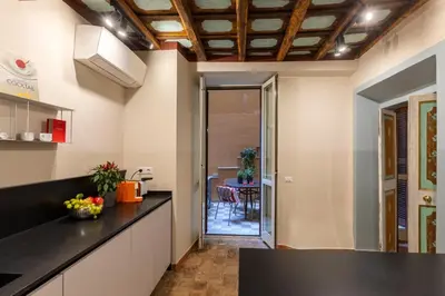 a kitchen with black countertops and a dining room at ROMAC Baullari IV Large apartment in Campo de' Fiori in Rome