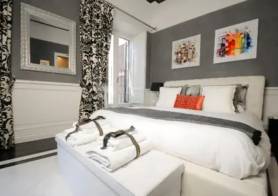 a bedroom with a large white bed and a window at Suite Spagna 29 in Rome