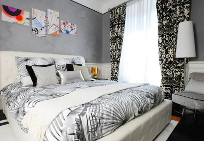 a bedroom with a bed with a black and white comforter at Suite Spagna 29 in Rome