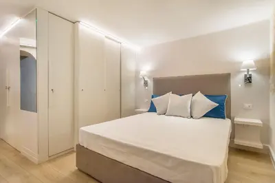 a bedroom with a large bed with blue and white pillows at Ciambella Atmosphere by Rental in Rome in Rome
